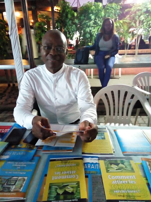 Claude Mpunga exposant ses opuscules à la 5e Fête du livre Claude Mpunga exposant ses opuscules à la 5e Fête du livre