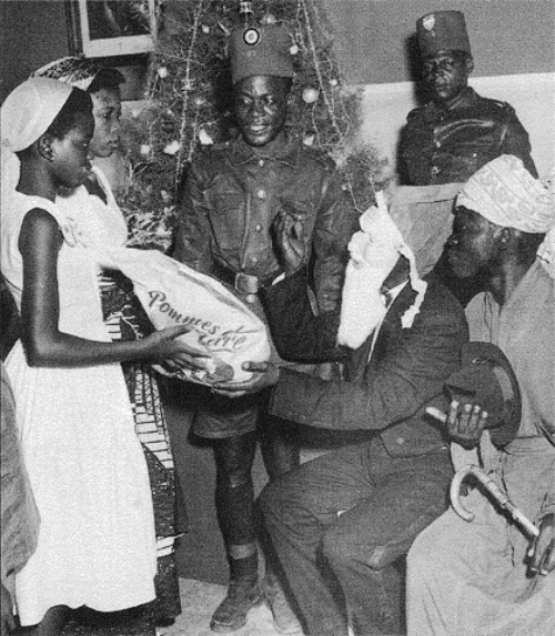 Le Père Noël distribuant un sac de pomme de terre 