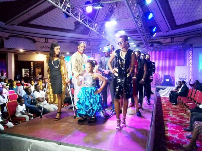  Le styliste Elie Aganze, derrière Esther, le mannequin nain qu’il a habillé  