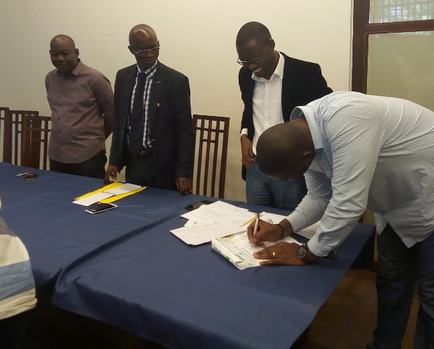 Un journaliste apposant sa signature à la charte d'engagement