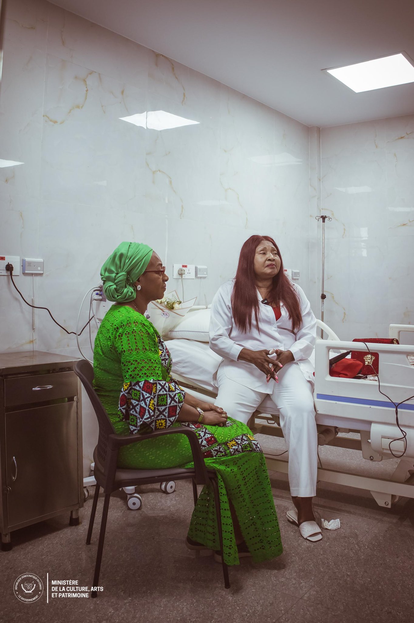1  : La Ministre Yolande Elebe visitant Mbilia Bel à l'hôpital / DR